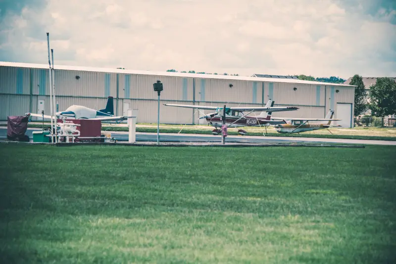 Small propeller plane parked at a regional airfield hangar