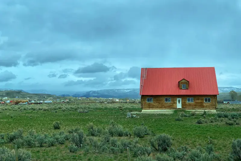 Red-roofed farmhouse on open country acreage