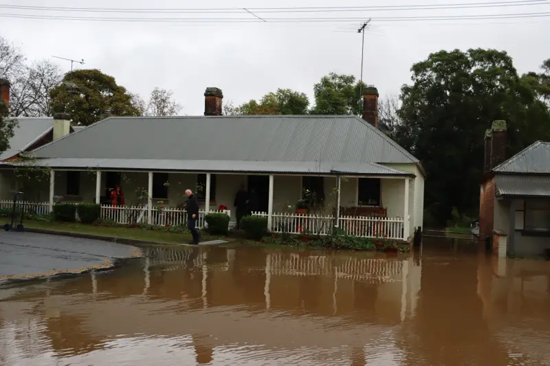 Single-storey house with floodwater across the yard