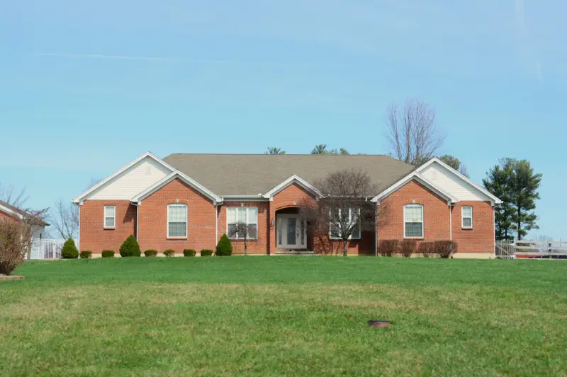 Brick single-family home with a wide front lawn